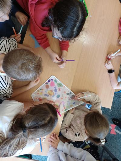 Dzieci ozdabiają klasowy latawiec.