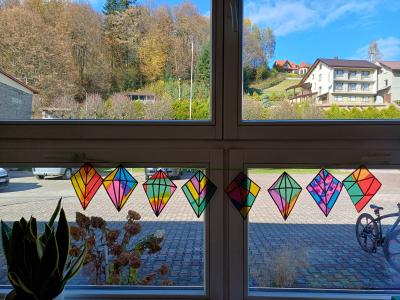 Witrażowe latawce wiszą w oknie.