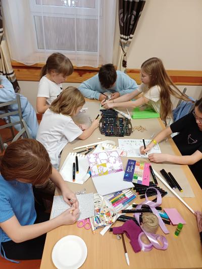 Uczniowie wykonują plakat na temat uzależnień.