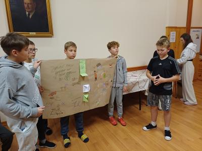 Uczniowie prezentują plakat o uzależnieniach.