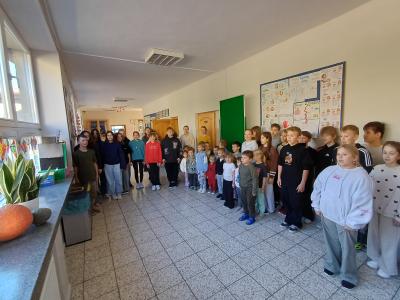 Uczniowie stoją i śpiewają Hymn Narodowy.