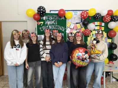 Uczniowie stoją w grupie w okularach z symbolami związanymi z Myszką Mickey.