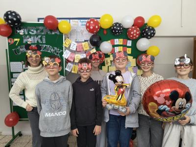 Uczniowie stoją w grupie w okularach z symbolami związanymi z Myszką Mickey.