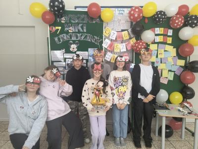 Uczniowie stoją w grupie w okularach z symbolami związanymi z Myszką Mickey.