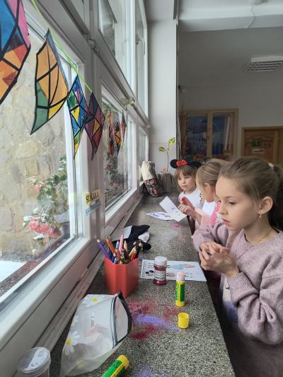 Uczniowie rozwiązują łamigłówki na parapecie szkolnym.