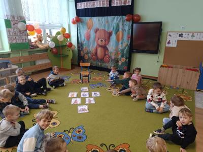 Dzieci siedzą w kole.