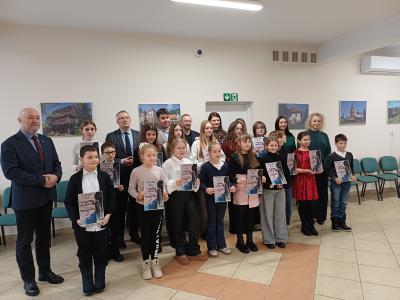 Laureaci konkursu wraz z jury i organizatorami pozują do zdjęcia.