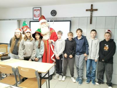 Uczniowie wraz ze św. Mikołajem pozują do wspólnego zdjęcia grupowego.