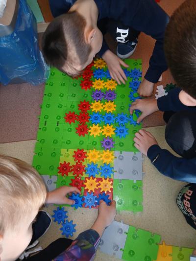 Uczniowie budują zagrody z klocków korbo.