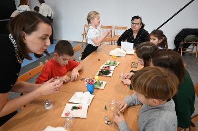 Rodzice wraz z dziećmi wykonują śnieżne kule.