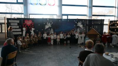 Przedszkolaki stoją na scenie i śpiewają pastorałkę.