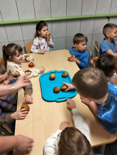 Dzieci jedzą upieczone muffinki.