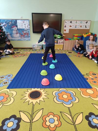 Dziecko chodzi po ścieżce sensorycznej.