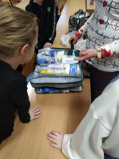 Pielęgniarka opowiada i pokazuje zawartość specjalistycznej apteczki.