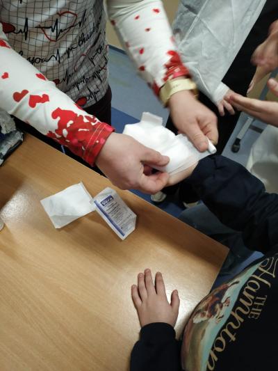 Pielęgniarka bandażuje rękę.