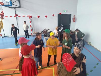 Uczniowie tańczą na sali gimnastycznej.