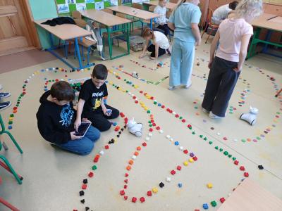 Uczniowie budują i kodują trasę dla robota Photon.