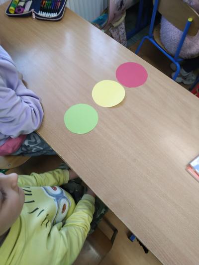 Kółka w kolorach zielonym, żółtym i czerwonym leżą na ławce.