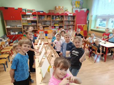 Dzieci przygotowują się do malowania farbami na płótnie.