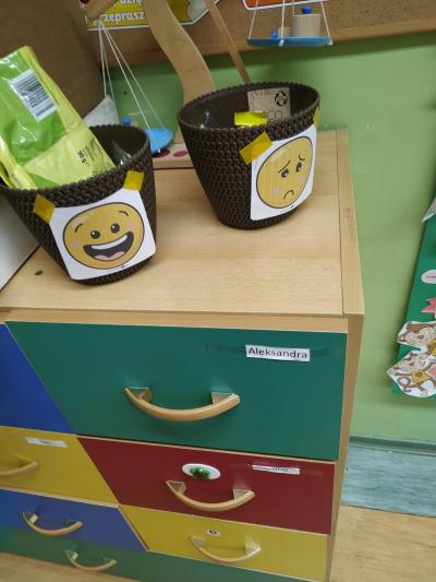 Koszyk uśmiechnięty i koszyk smutny z pustymi opakowaniami po przekąskach.