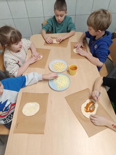 Dzieci robią swoje pizzy.