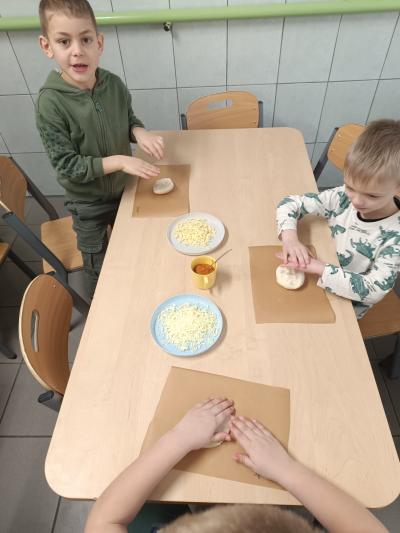 Dzieci robią swoje pizzy.