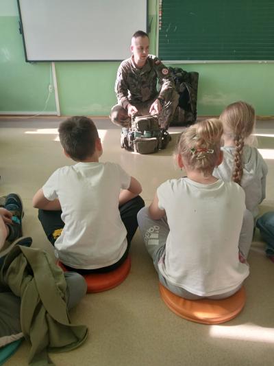 Żołnierz opowiada o wyposażeniu plecaka.
