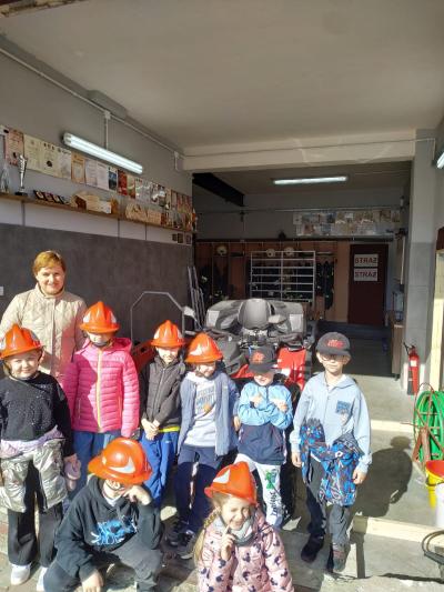 Uczniowie mają na głowach kaski strażackie.