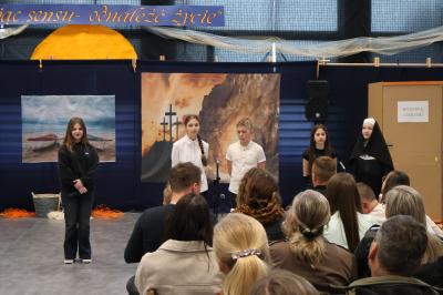 Uczniowie stoją w grupie i śpiewają pieśń.