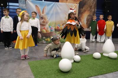 Na scenie przedszkolaki przebrane za kurę, kurki, baranka, zająca oraz jajka.