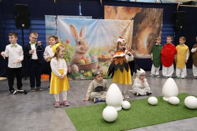 Na scenie przedszkolaki przebrane za kurę, kurki, baranka, zająca oraz jajka.