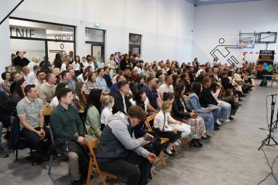 Uczniowie i rodzice oraz zaproszeni goście siedzą na krzesłach, jako widownia.