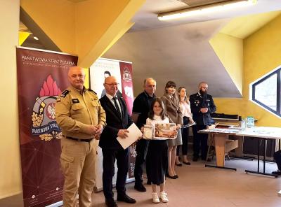 Uczennica z jury i nagrodami.