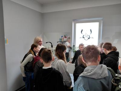 Uczniowie słuchają pani w pokoju zabiegowym.