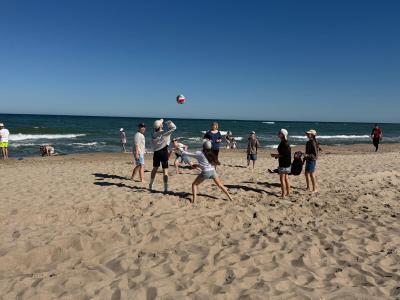 Uczniowie grają w piłkę na plaży.