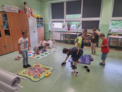 Uczniowie tańczą na matach grających.