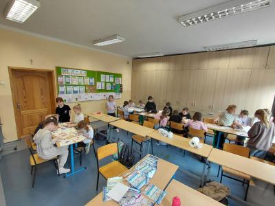 Uczniowie tworzą obrazki malowane piaskiem.