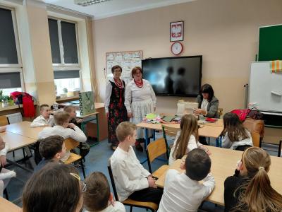 Uczniowie uczą się szyć na maszynie do szycia.