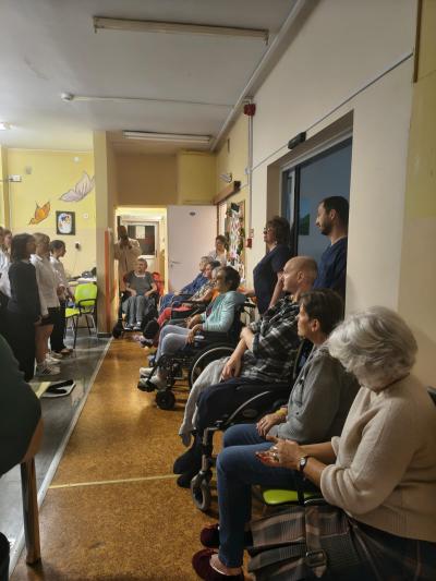Pacjenci i personel medyczny oglądają występ.