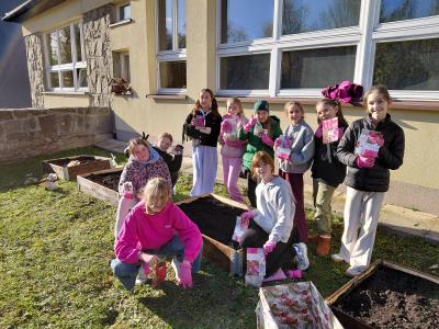 Zdjęcie grupowe uczniów z cebulkami tulipanów.
