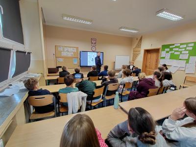 Uczniowie słuchają policjanta.
